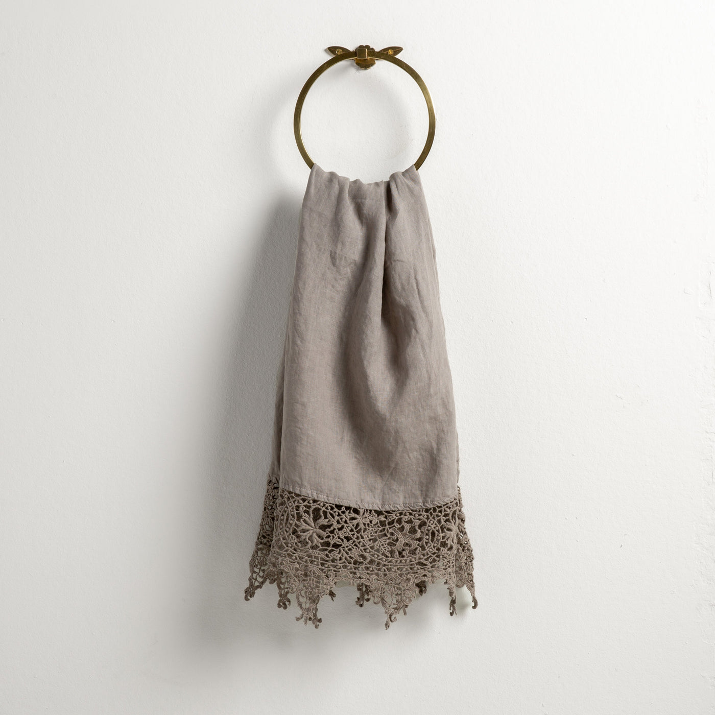 Fog Frida guest towel hung on brass ring, showing crochet lace hem detail.