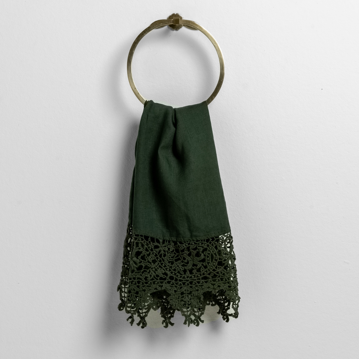 Juniper guest towel draped on brass ring, showing intricate floral crochet lace trim at hem.