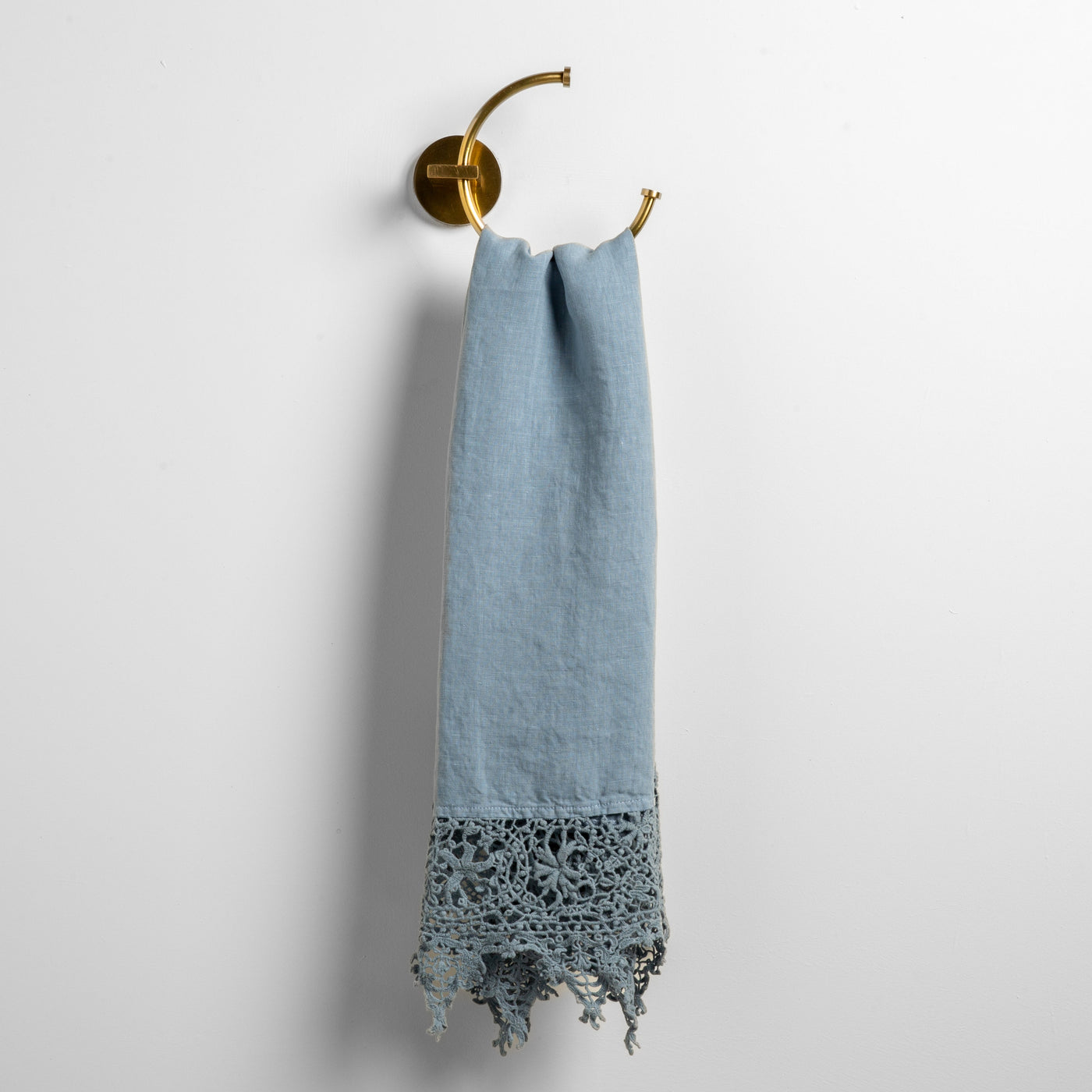 Tahoe Blue guest towel draped on brass ring hook, showing lace crochet hem detail at bottom edge.