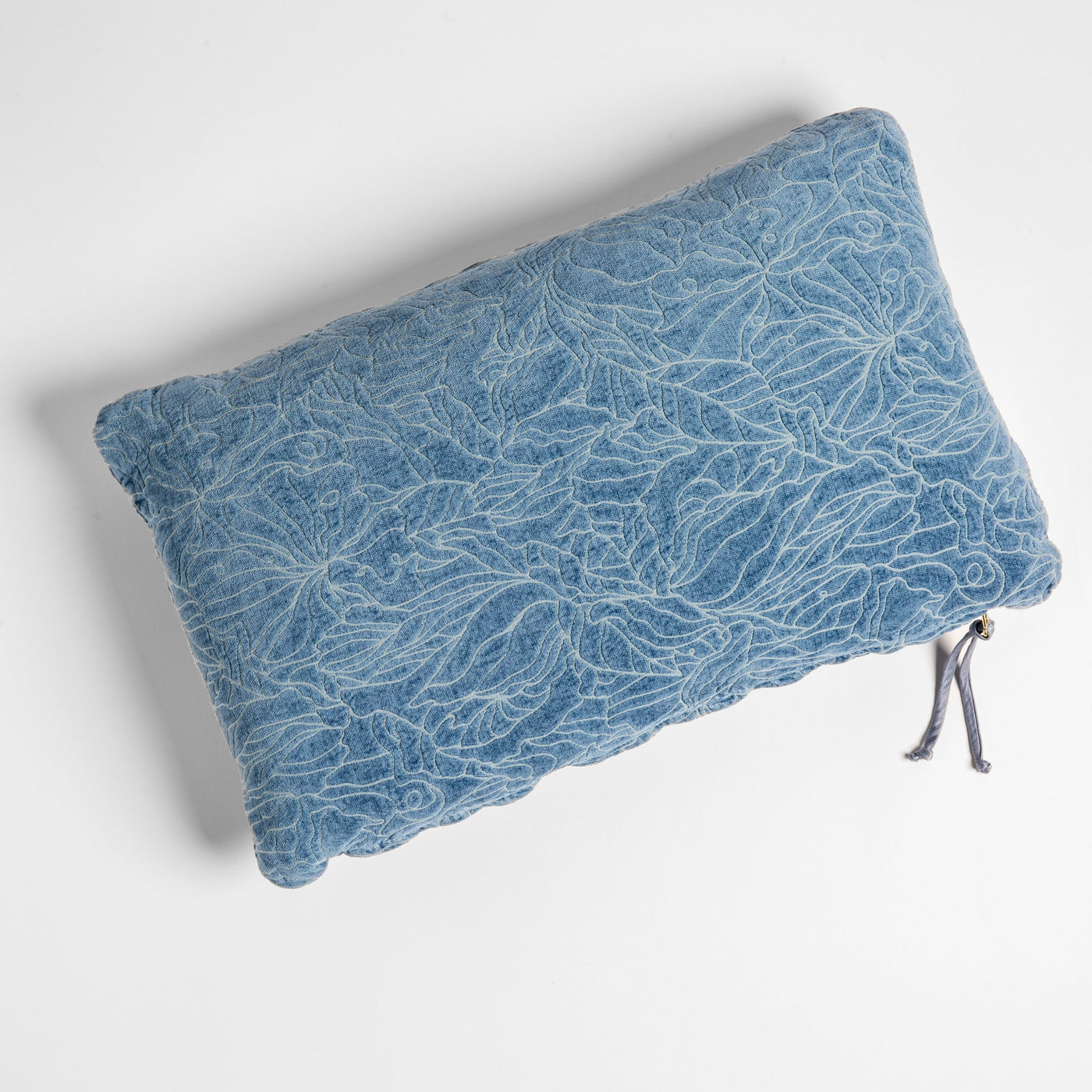 Georgia throw pillow in Tahoe Blue, overhead view showing floral lace texture and tassel zip detail.