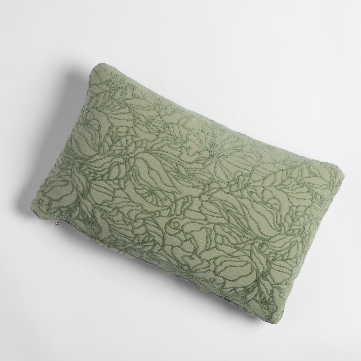Desert Sage lumbar throw pillow with tonal floral quilted pattern, angled overhead view.