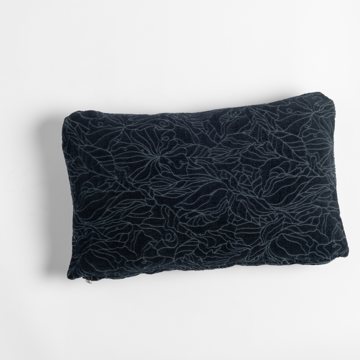 Slate velvet lumbar throw pillow with tonal floral outline embroidery, angled flat lay view.