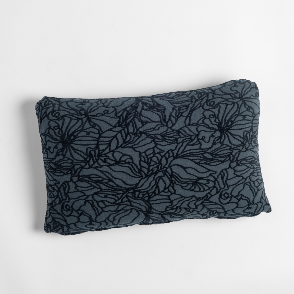 Slate lumbar throw pillow with dark floral outline pattern, shown against white background.