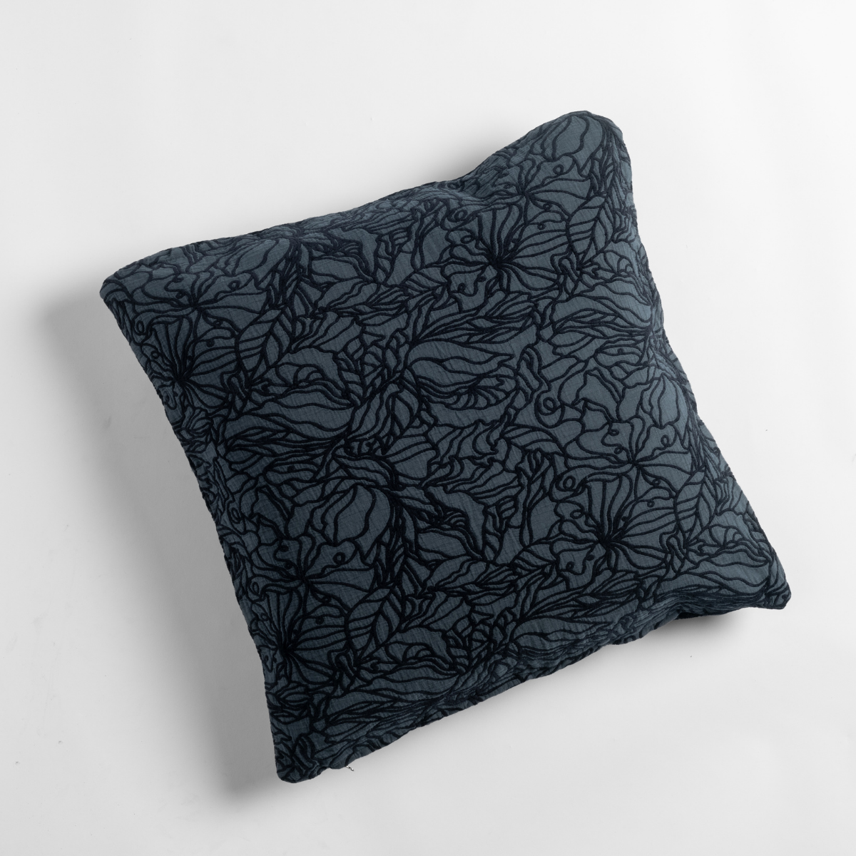 Slate Georgia throw pillow showing floral outline quilting detail against soft white background.