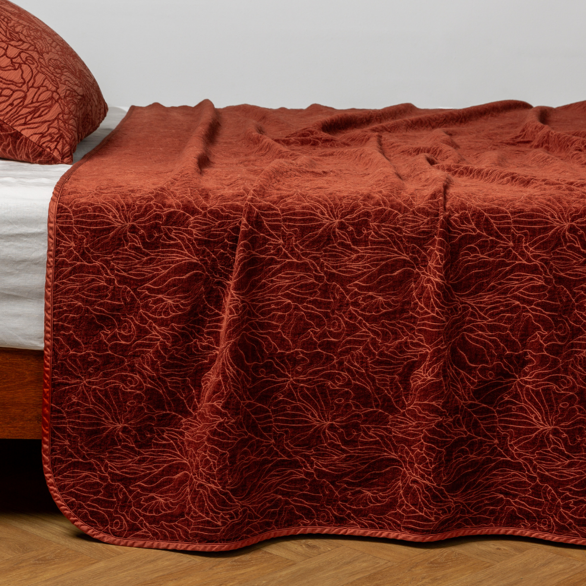 Autumn Georgia bedspread draped over bed, showing allover floral embroidery detail.