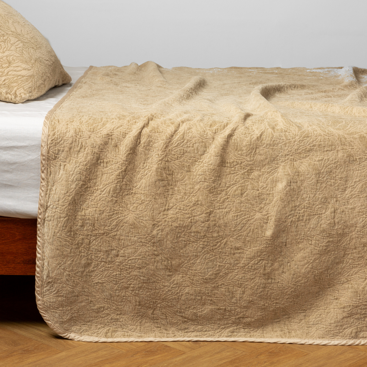 Honeycomb Georgia bedspread draped over bed edge, showing quilted floral texture and trim detail.