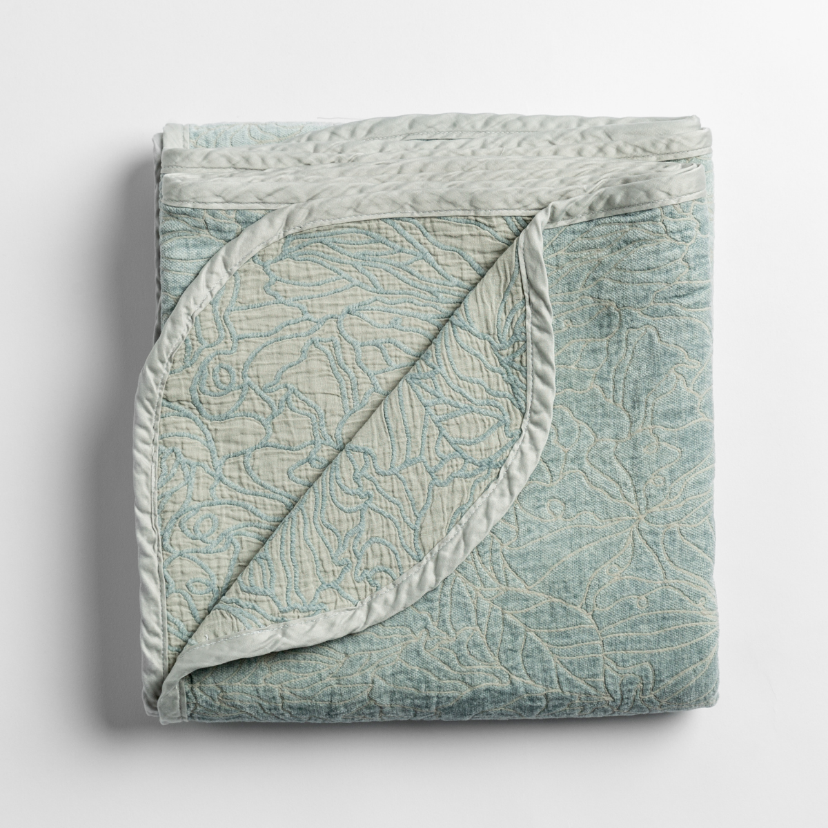 Folded Cloud Georgia blanket corner turned back, revealing quilted texture and satin trim detail.