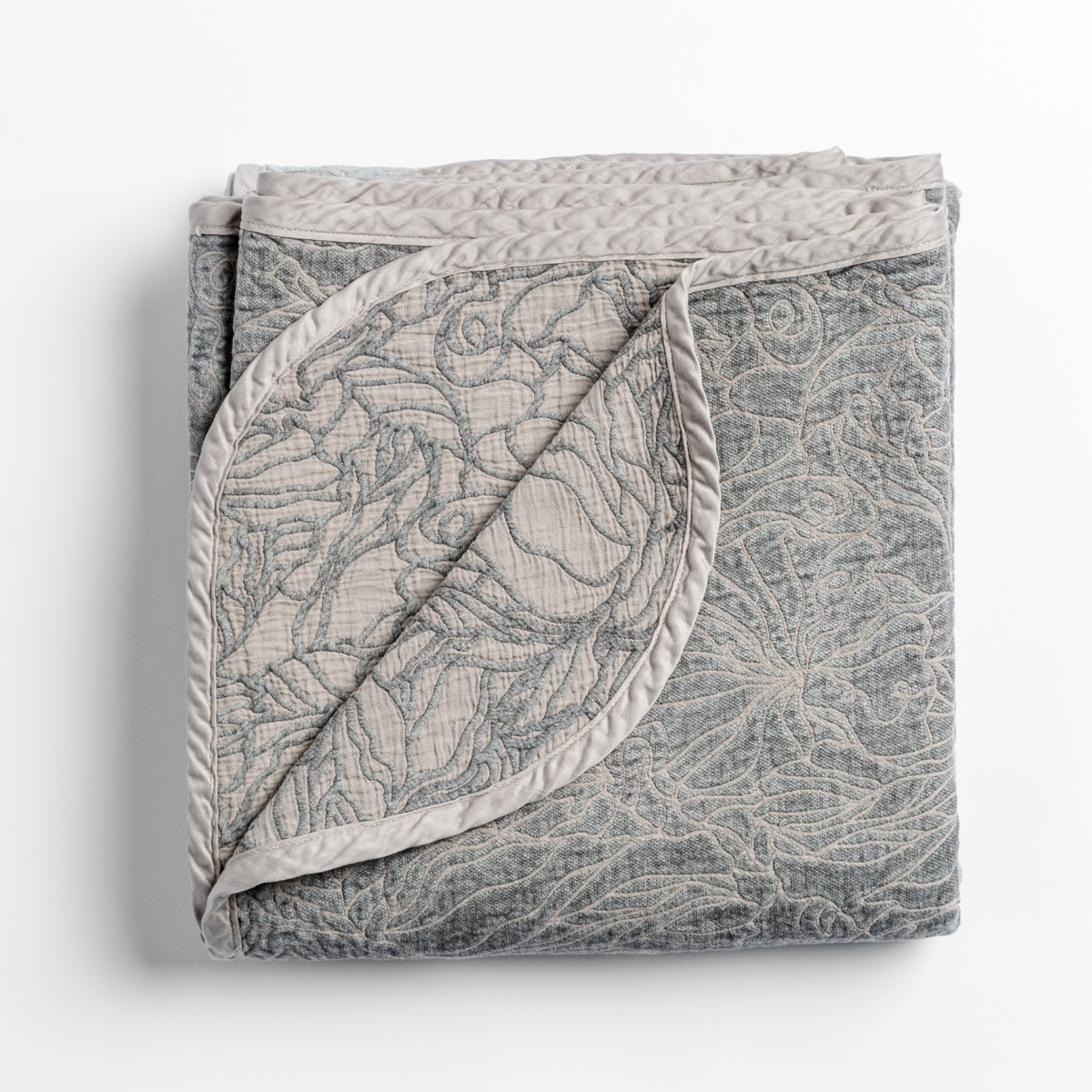Bella Notte Georgia blanket in Fog folded, showing floral quilted face and contrast reverse.