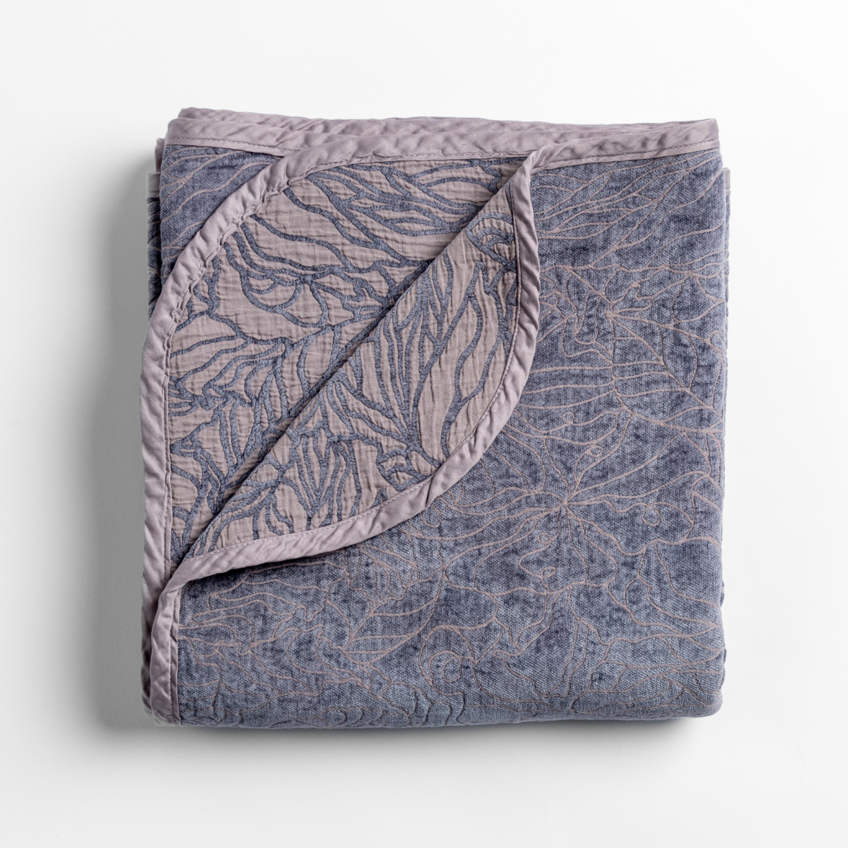 Folded French Lavender Georgia throw with corner turned back, revealing botanical jacquard pattern.