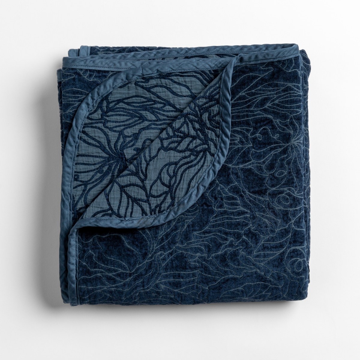 Bella Notte Georgia blanket in Midnight, folded to show floral embroidered velvet texture and corded trim.