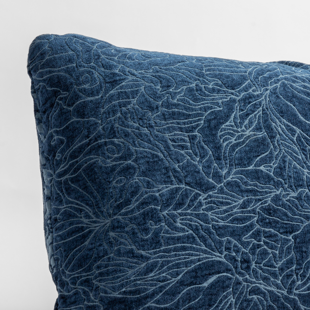 Close-up of Midnight velvet throw pillow with raised floral scroll quilting detail.