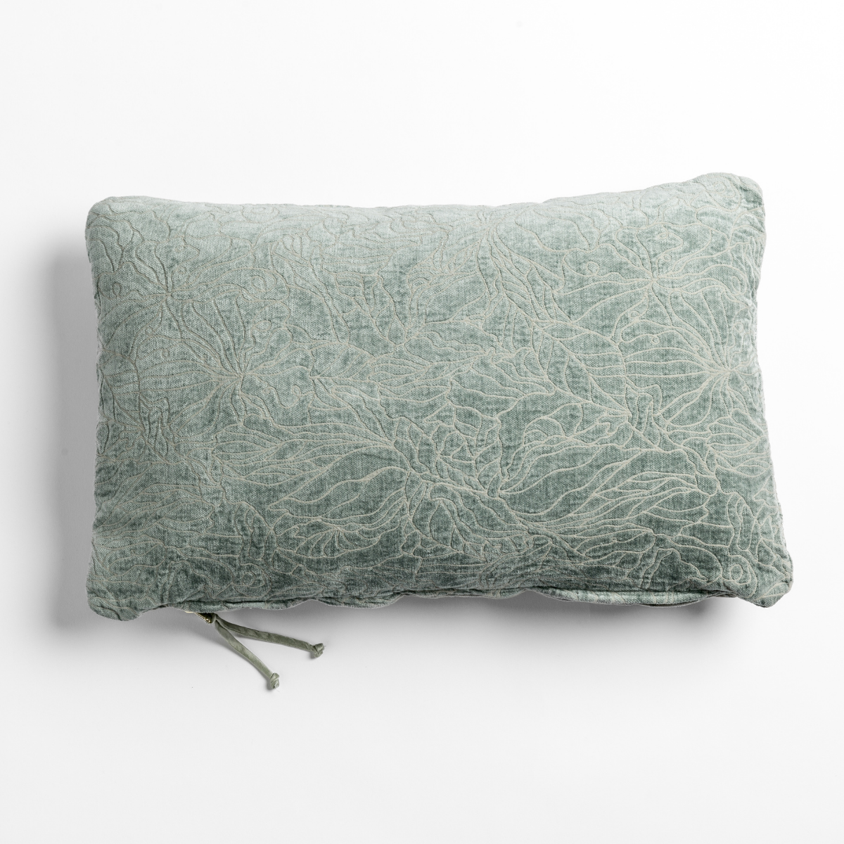 Eucalyptus velvet throw pillow with crinkled floral texture and tassel tie detail.