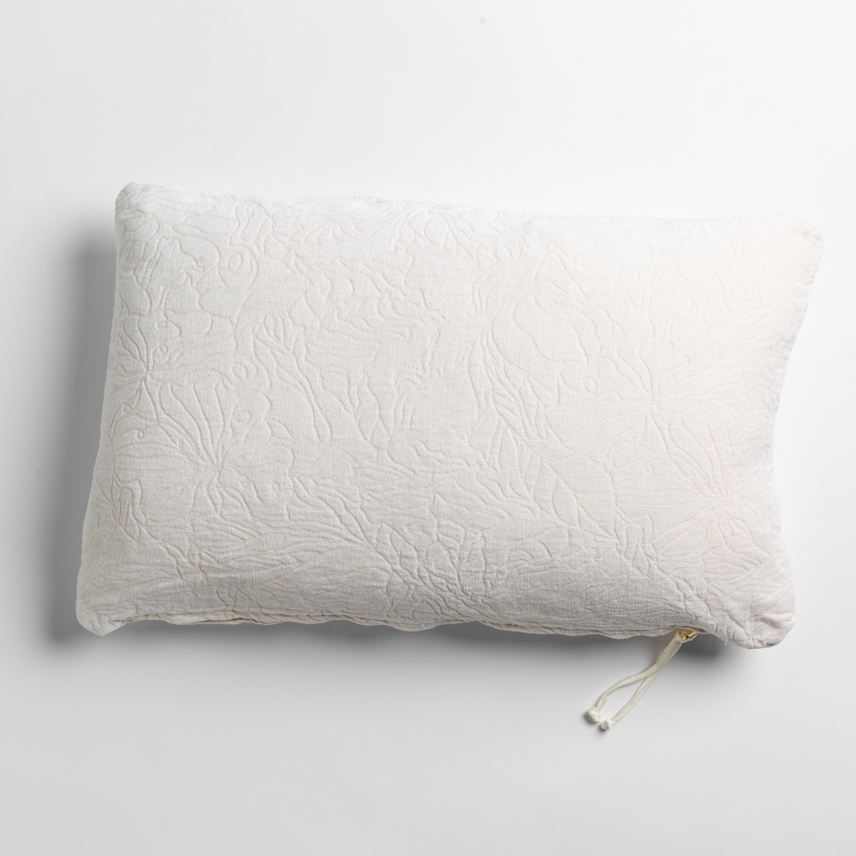 Bella Notte Georgia throw pillow in Winter White, overhead view showing quilted floral texture and tassel zipper.