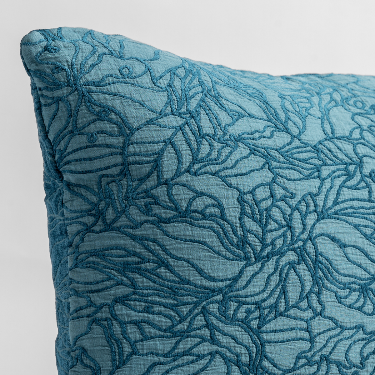 Close-up of Bella Notte Georgia sham corner in Cenote, showing quilted floral vine texture.