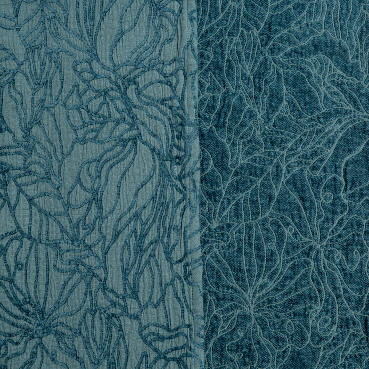 Close-up of Cenote Georgia bedspread showing floral embroidery detail on two tonal blue fabric panels.