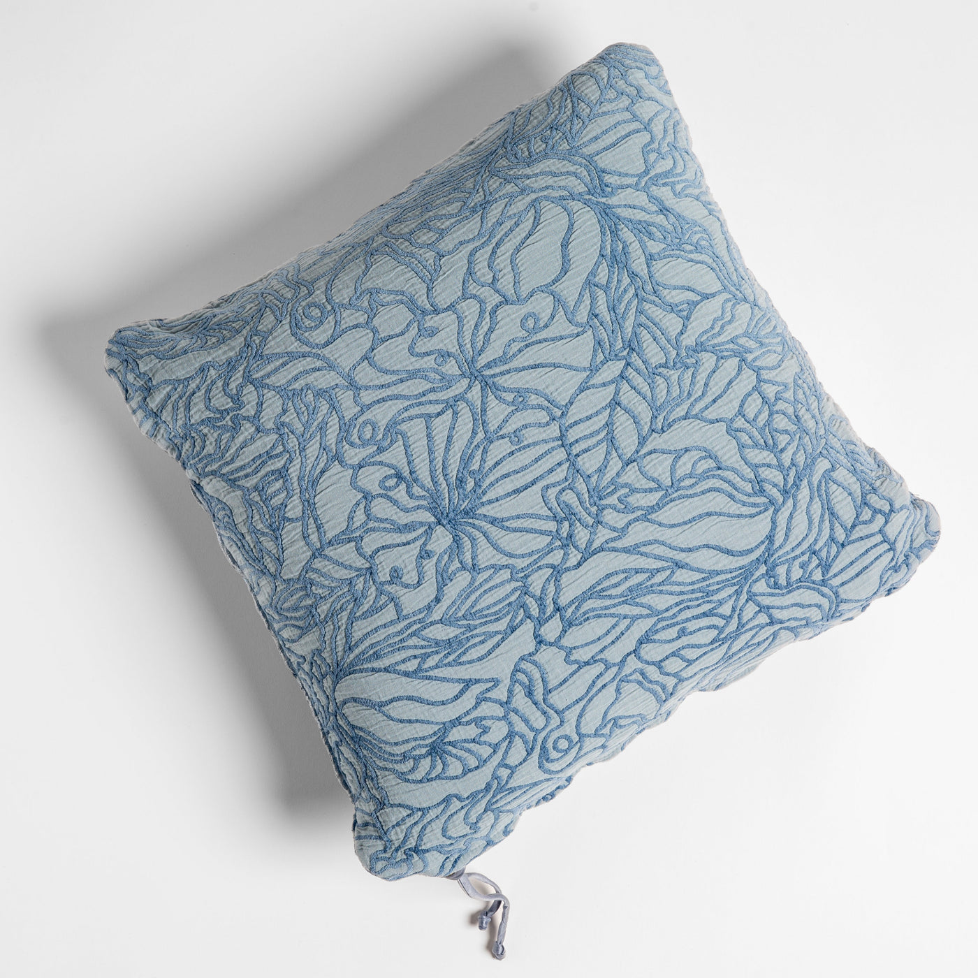 Bella Notte Georgia throw pillow in Tahoe Blue, floral outline embroidery, overhead view.