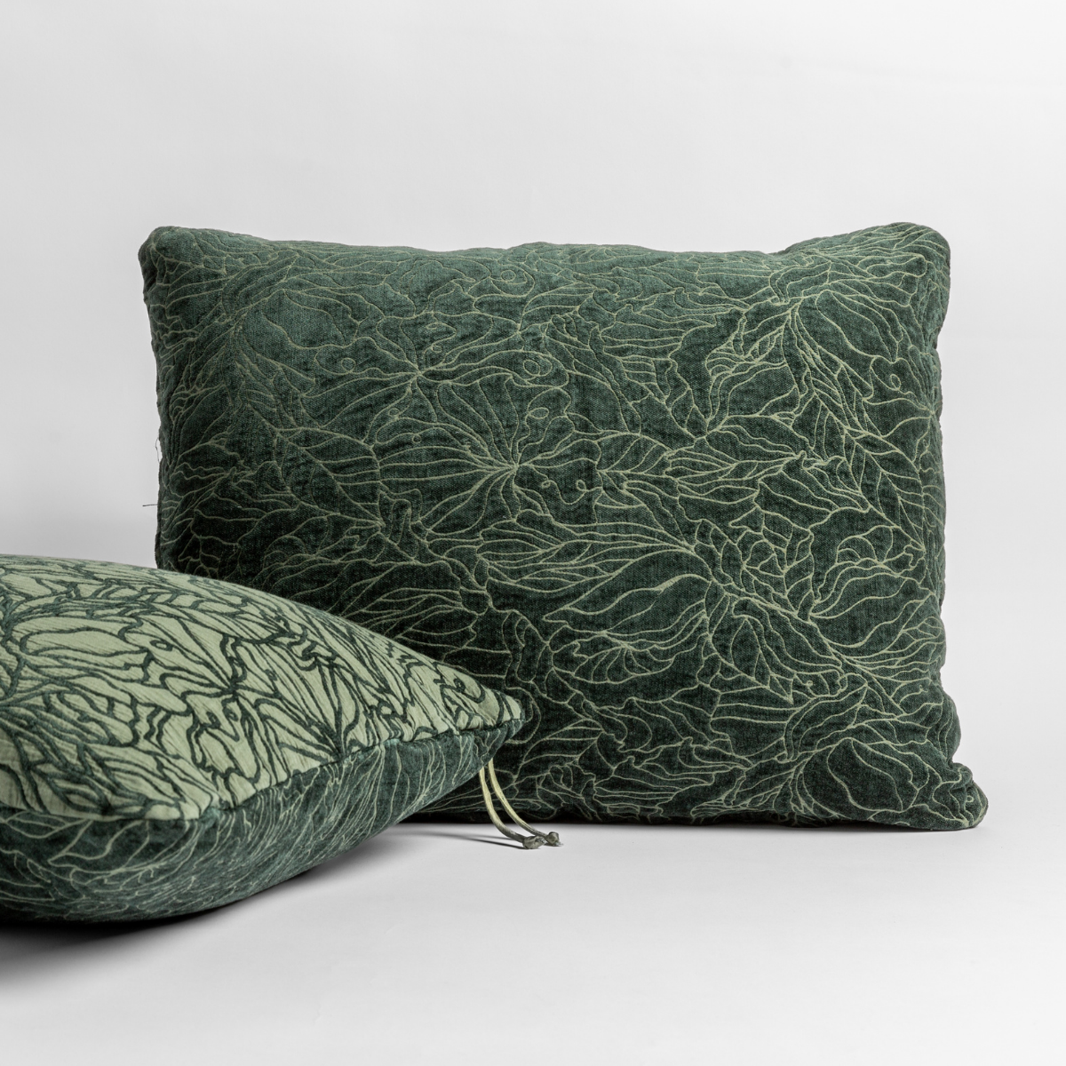 Two Bella Notte Georgia shams in Juniper, showing floral embroidery detail and tassel corner trim.
