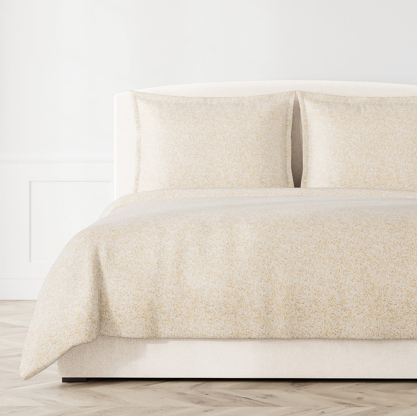 Ann Gish Glacier coverlet in ivory, styled on bed with matching shams, subtle textured pattern.