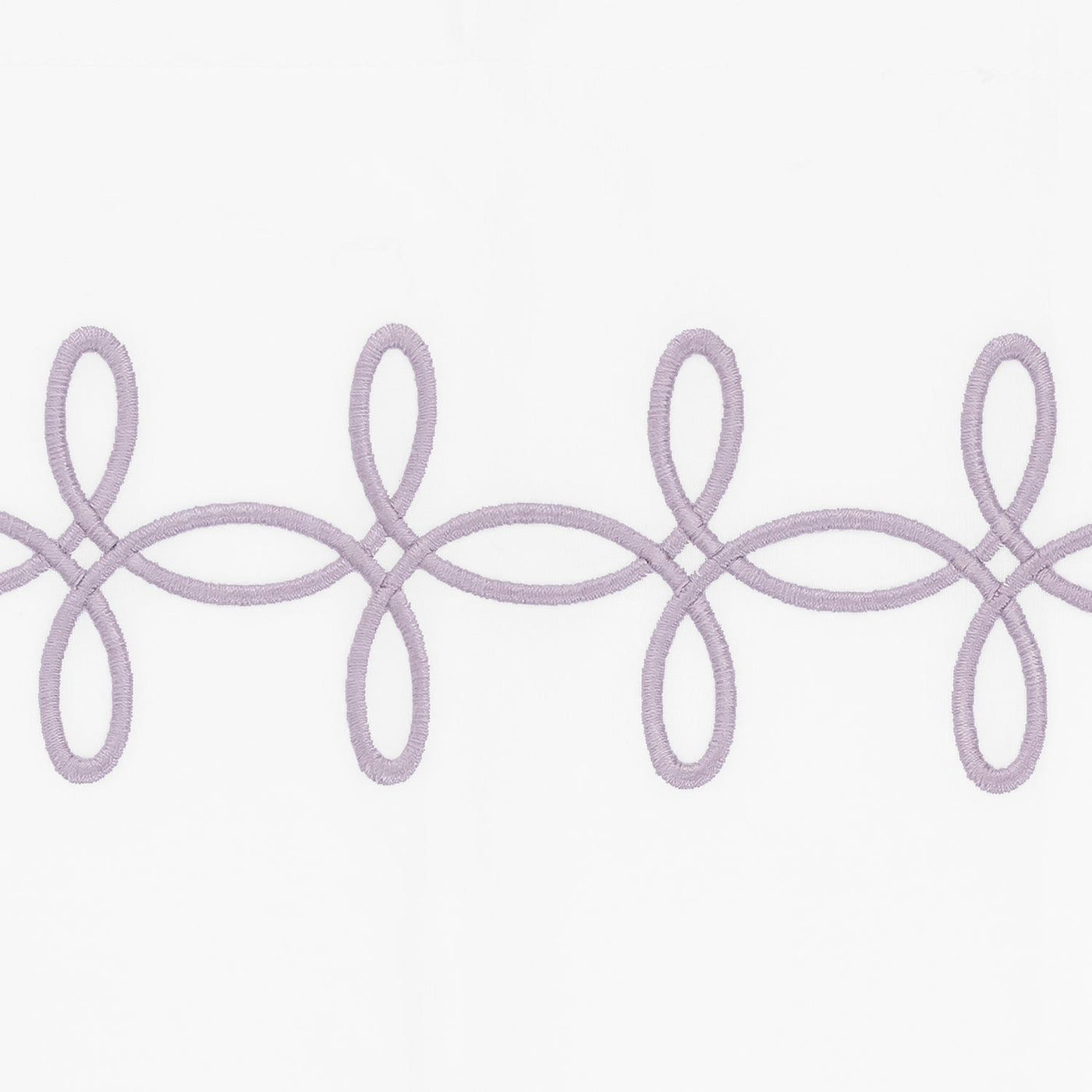 Close-up of lavender Gordian Knot embroidery border on white cotton fabric.