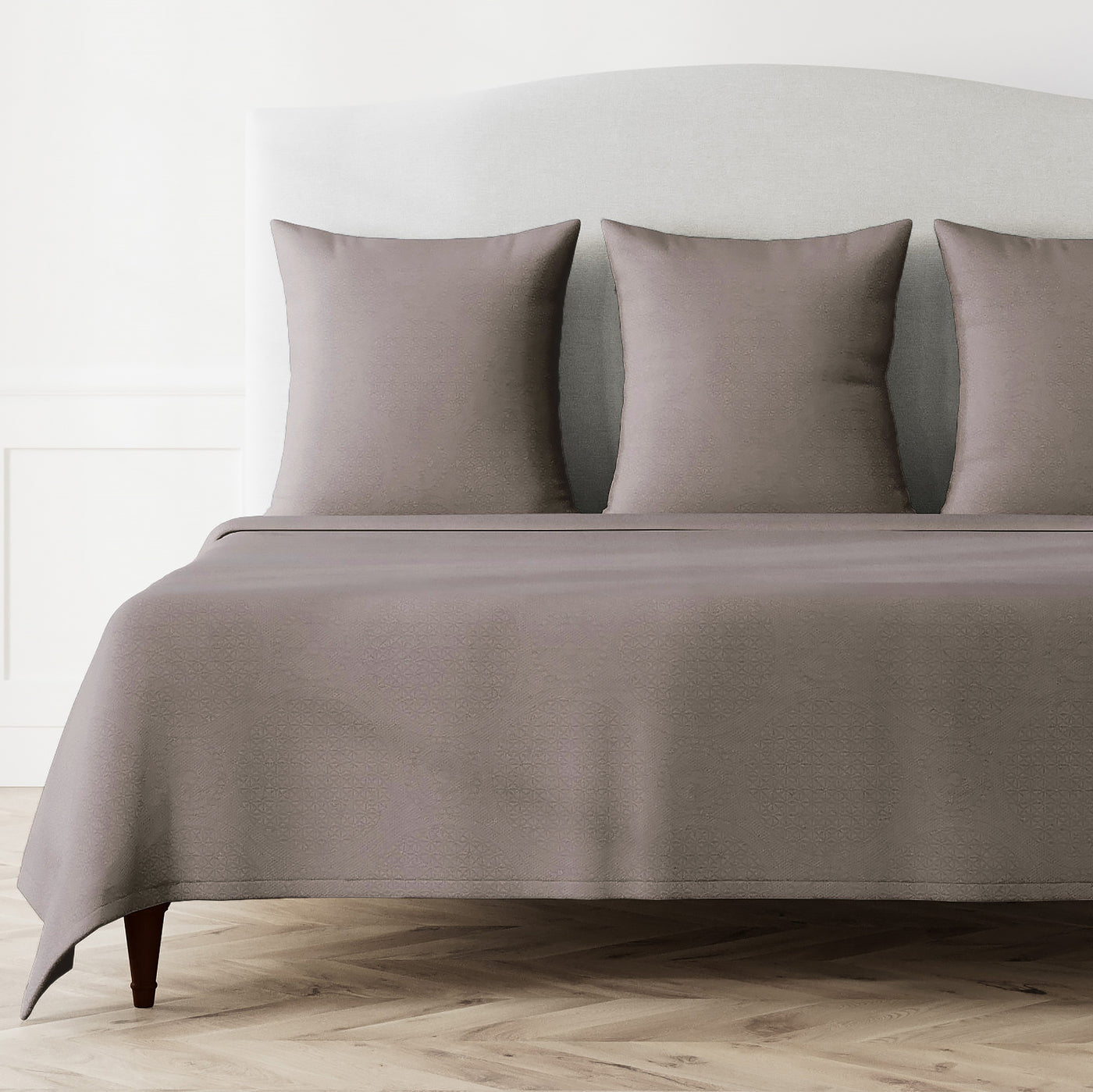 Ann Gish Great Hall coverlet set in taupe, styled on a bed with matching pillow shams.