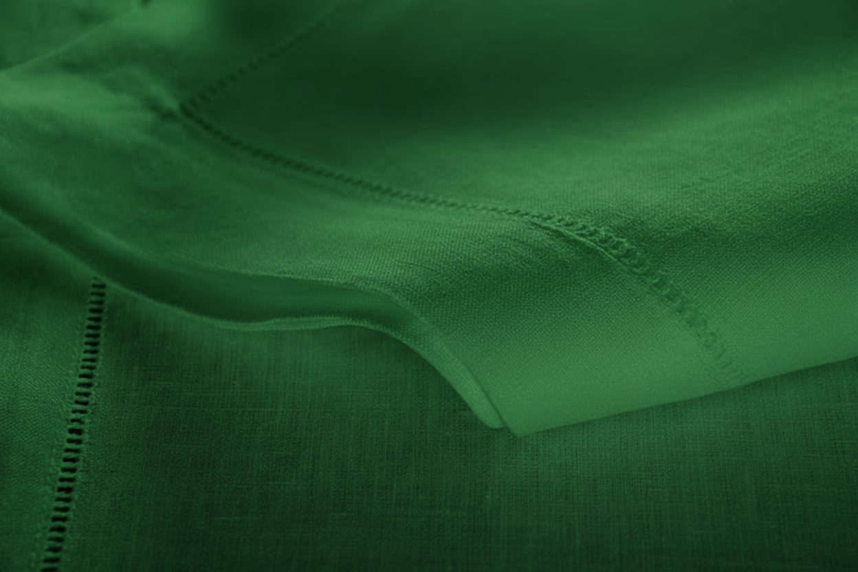 Close-up of emerald green linen with hemstitch border detail.