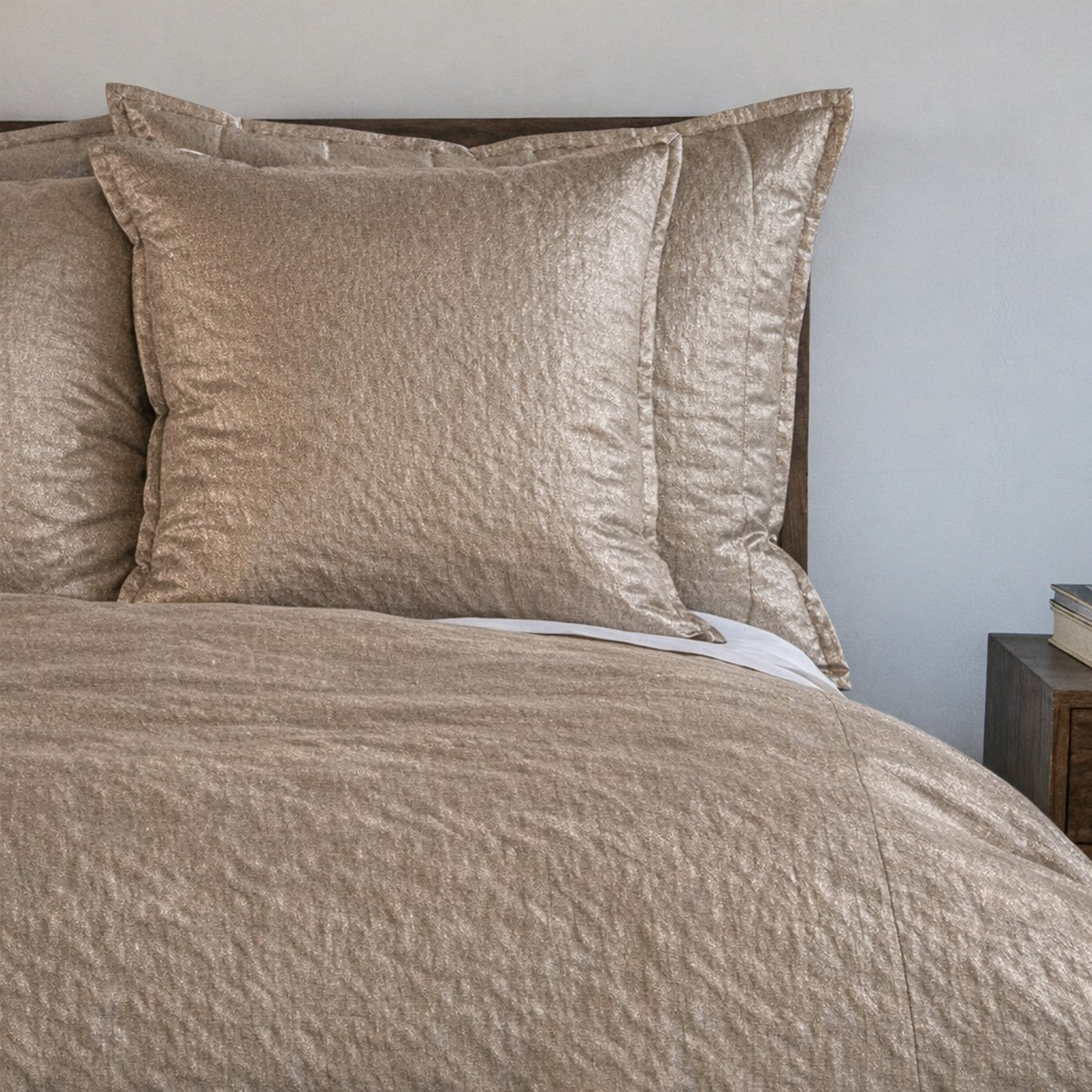 Angled view of Ann Gish Hammered duvet cover in champagne with textured quilted surface.