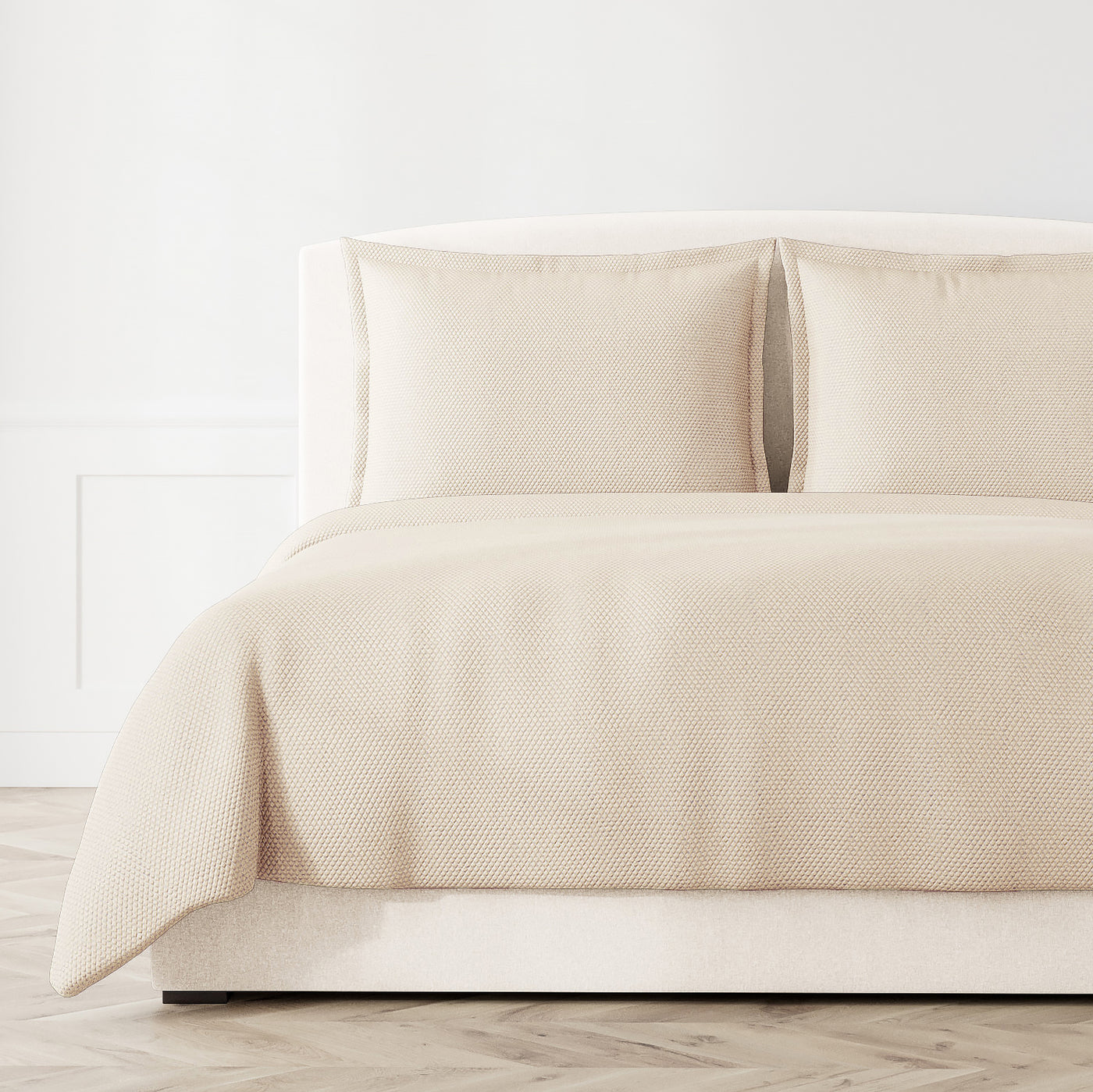 Ann Gish Hollywood coverlet in ivory, textured woven pattern on styled bed with matching shams.