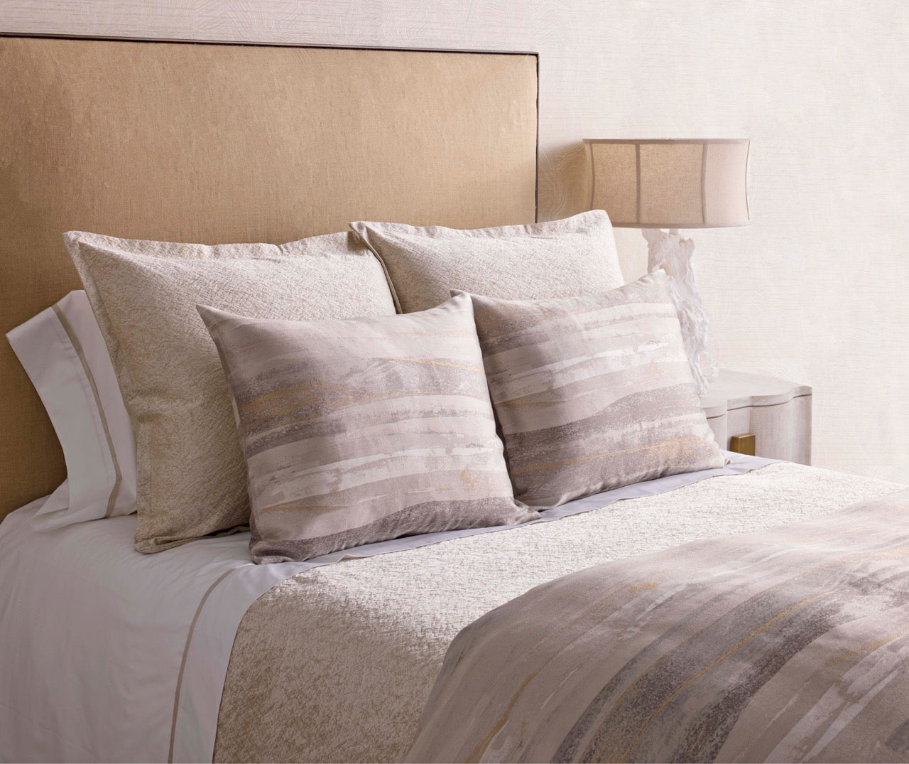 Horizon duvet and pillow shams styled on a bed in taupe and ivory tones.