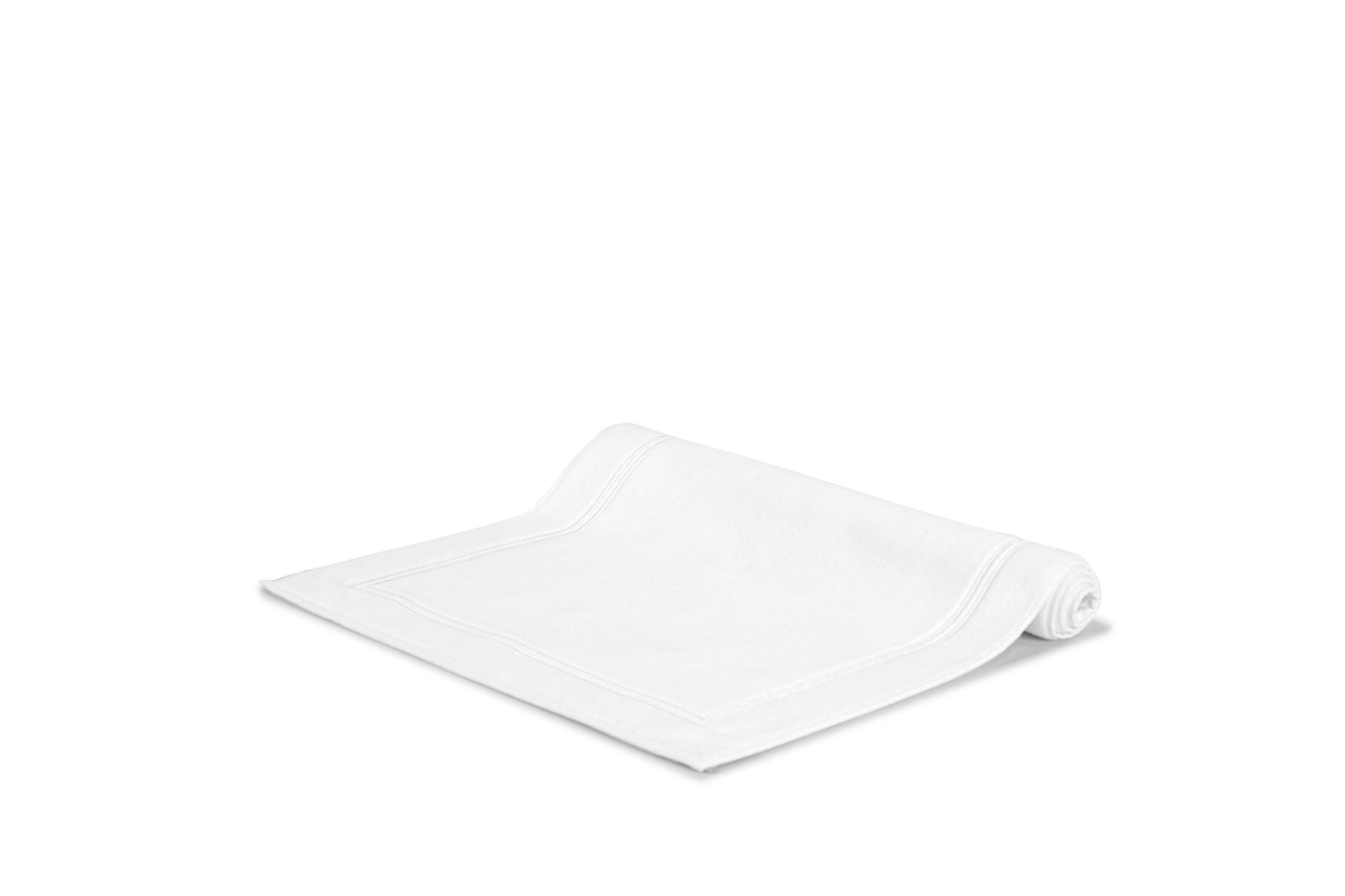 The Frette Classic Bath Mat by Frette, from the luxury bath collection, features a subtle stitched border and is displayed on a plain white background.