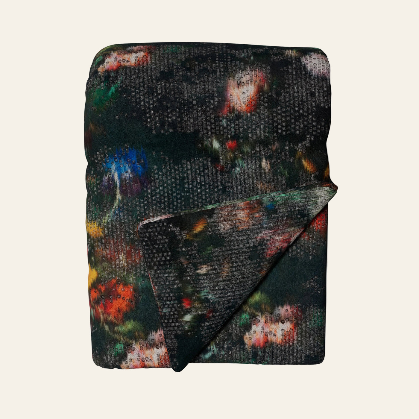 Ann Gish Ibiza throw, dark charcoal knit with multicolor abstract floral print, folded.