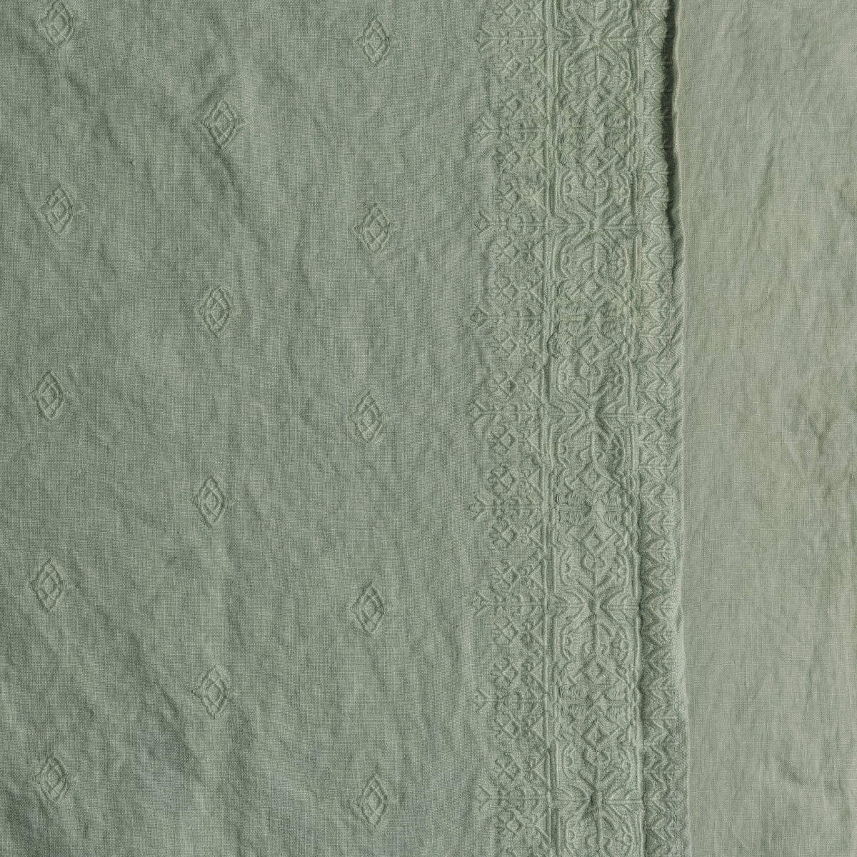 Close-up of Desert Sage sham showing tonal diamond motifs and ornate embroidered border detail.