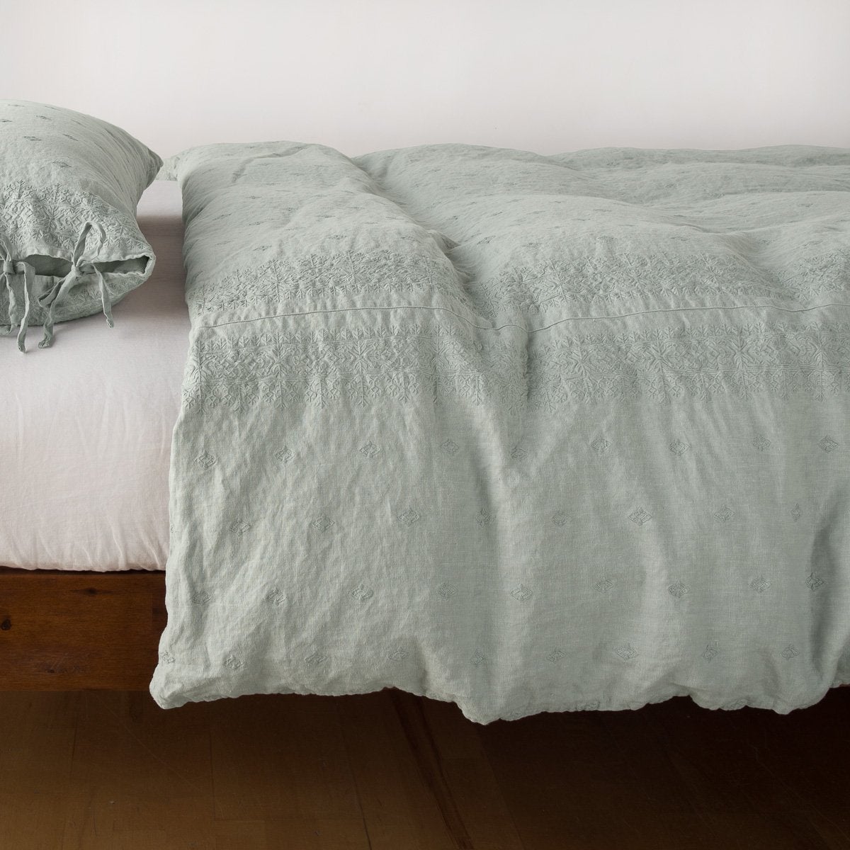 Eucalyptus linen duvet cover draped over a bed, shown with matching pillowcase.