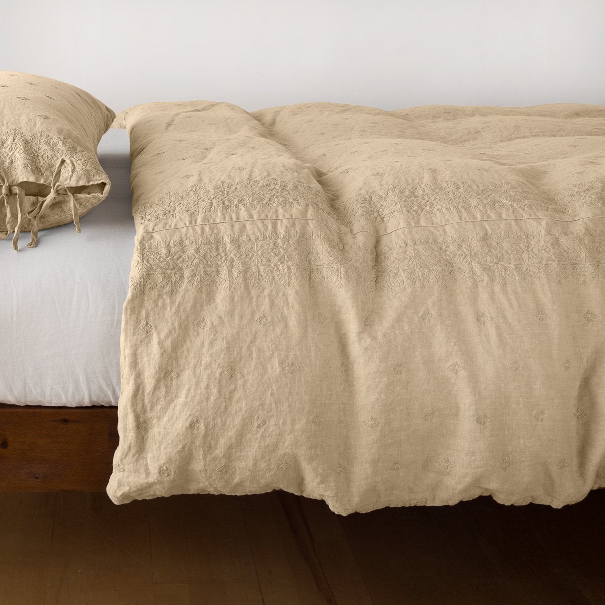 Honeycomb linen duvet cover draped over bed, relaxed texture with matching tie-closure pillow.