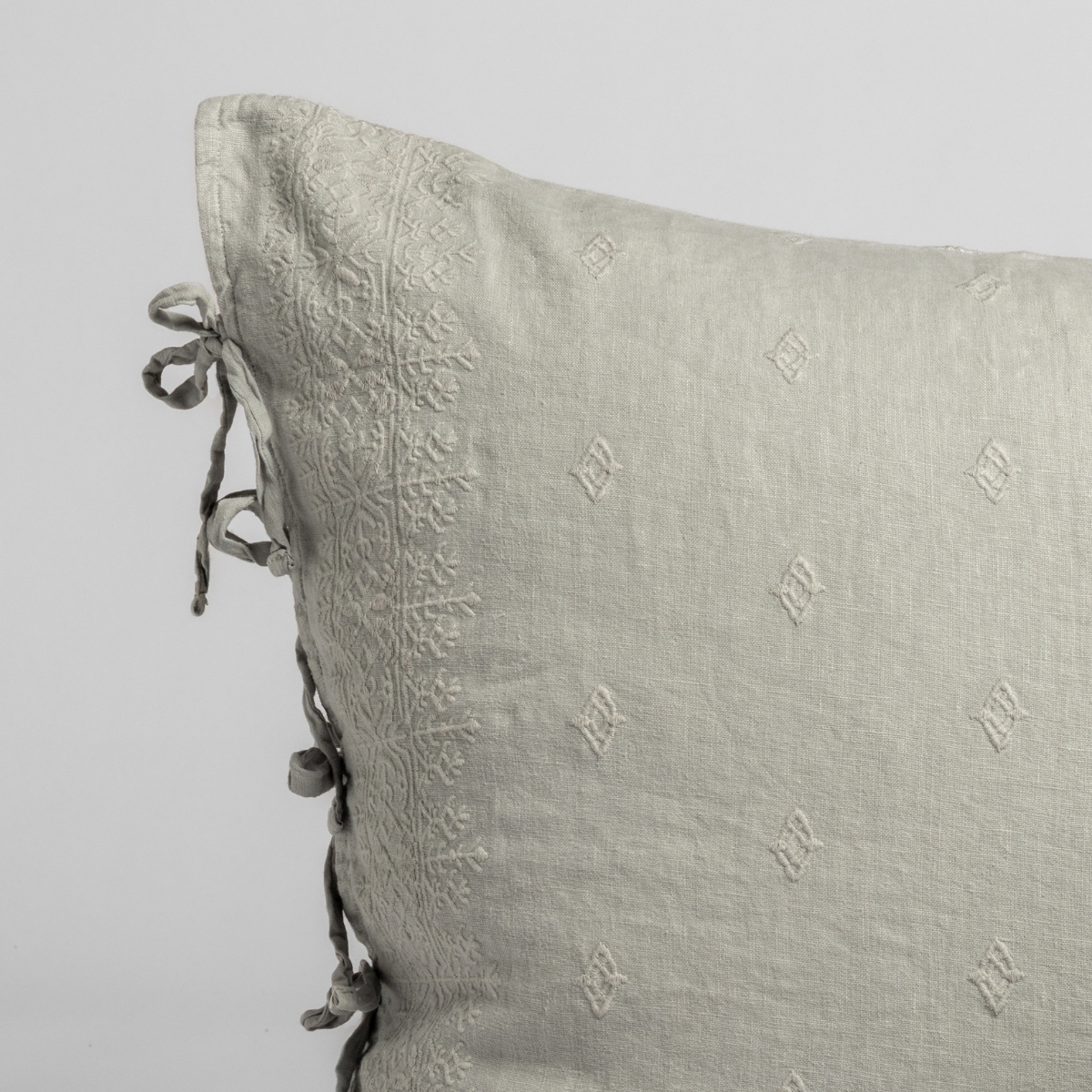 Close-up of Cloud Bella Notte Ines sham corner with embroidered diamond motifs and tied linen bow closure.