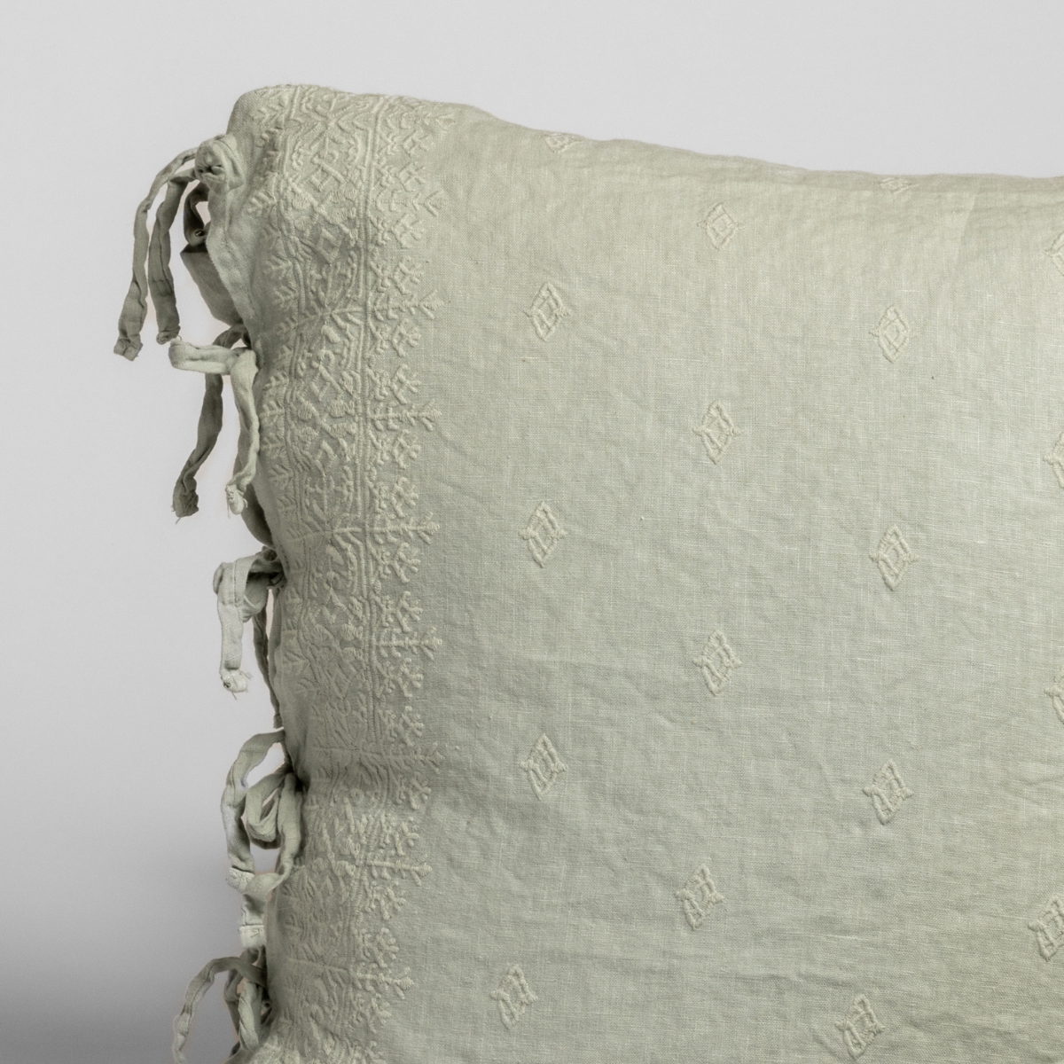 Close-up of Eucalyptus Ines sham corner with tone-on-tone embroidery and tassel ties.