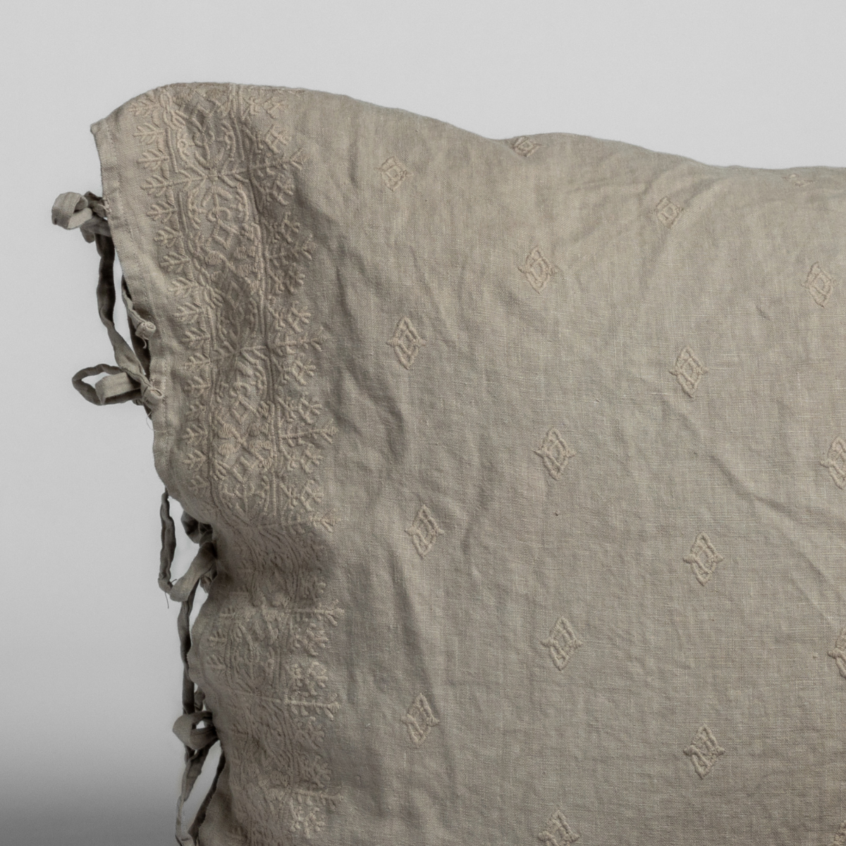 Close-up of Fog Bella Notte Ines sham corner showing tone-on-tone monogram pattern and tie closure.