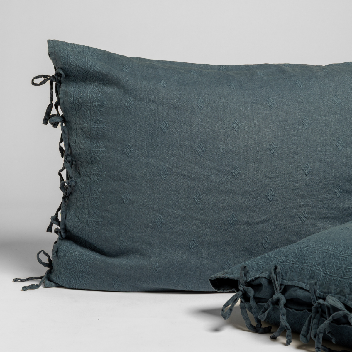Close-up of Midnight Bella Notte Ines sham showing embroidered linen texture and tassel tie closure.