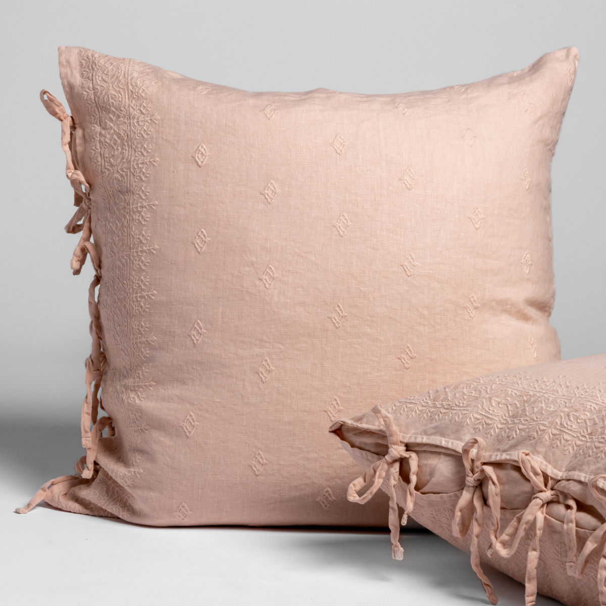 Bella Notte Ines sham in Pearl, showing embossed texture and side tie details on two stacked shams.