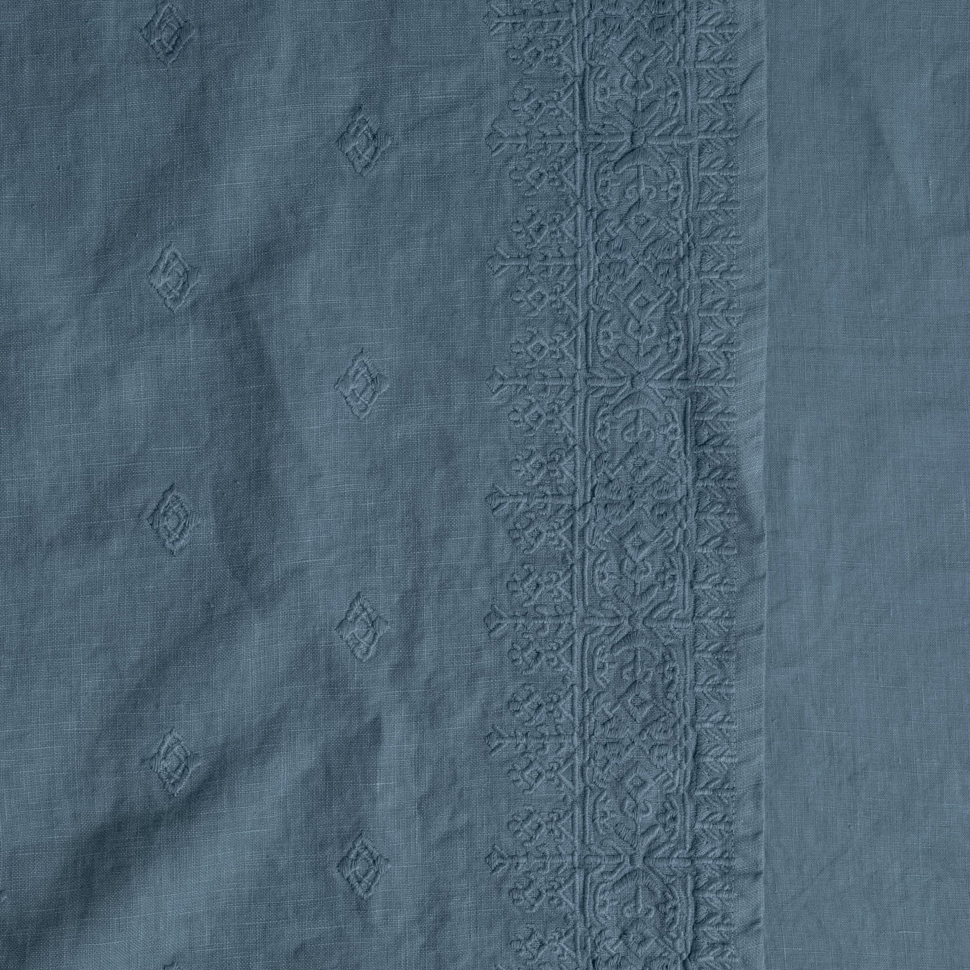 Close-up of Tahoe Blue linen with tonal diamond embroidery and detailed border trim.