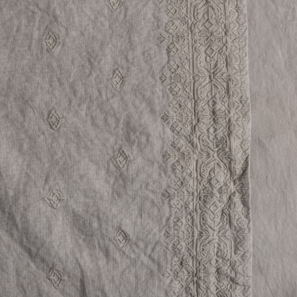Close-up of Fog linen sham showing geometric embroidered border and diamond motif field detail.