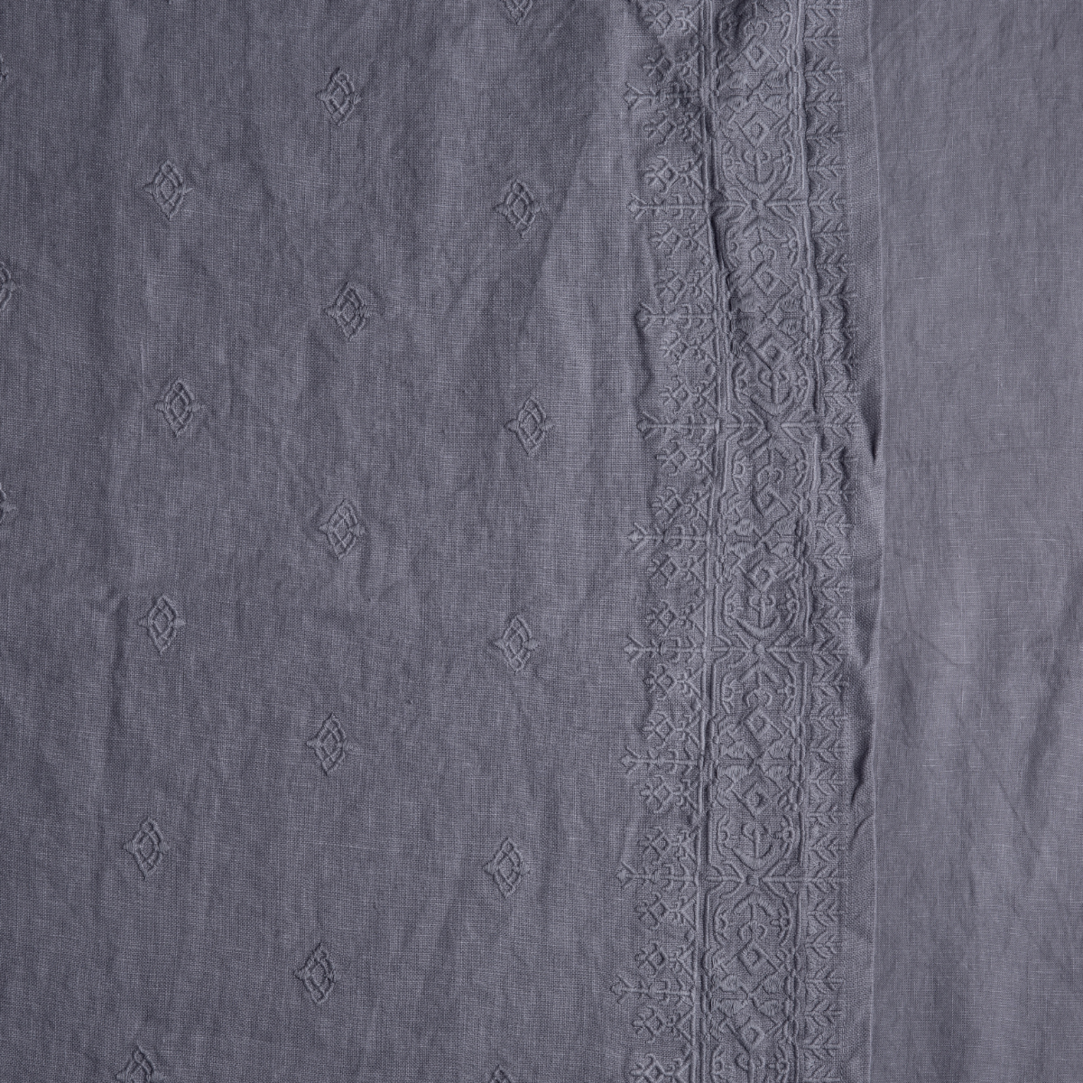Close-up of French Lavender linen sham with tonal diamond embroidery and ornate border trim.
