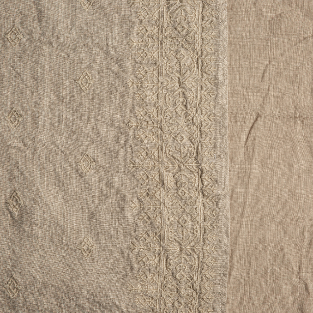 Close-up of Honeycomb linen duvet cover with tonal embroidered border and diamond motifs.