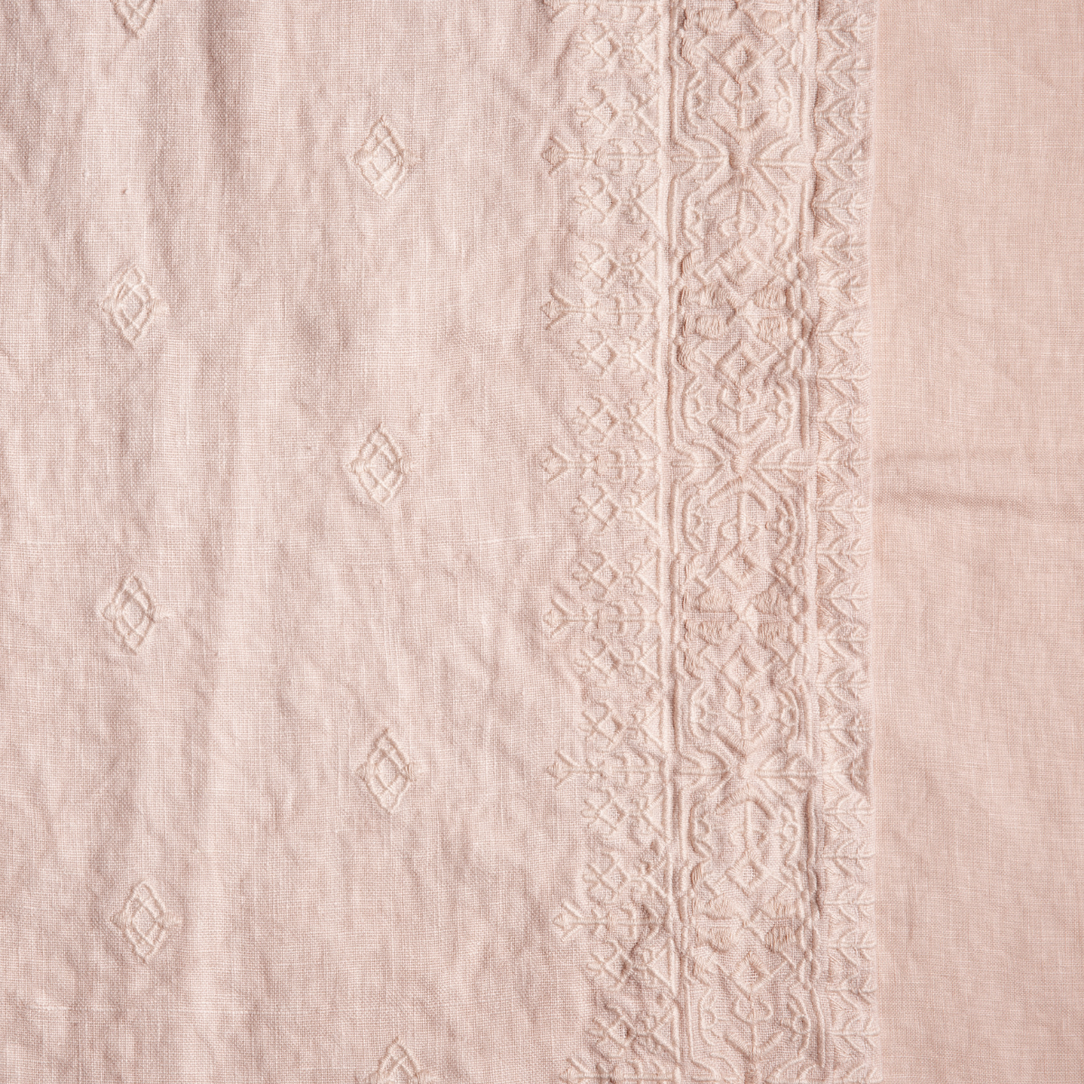 Close-up of Pearl linen duvet cover with tone-on-tone diamond embroidery and geometric border trim.