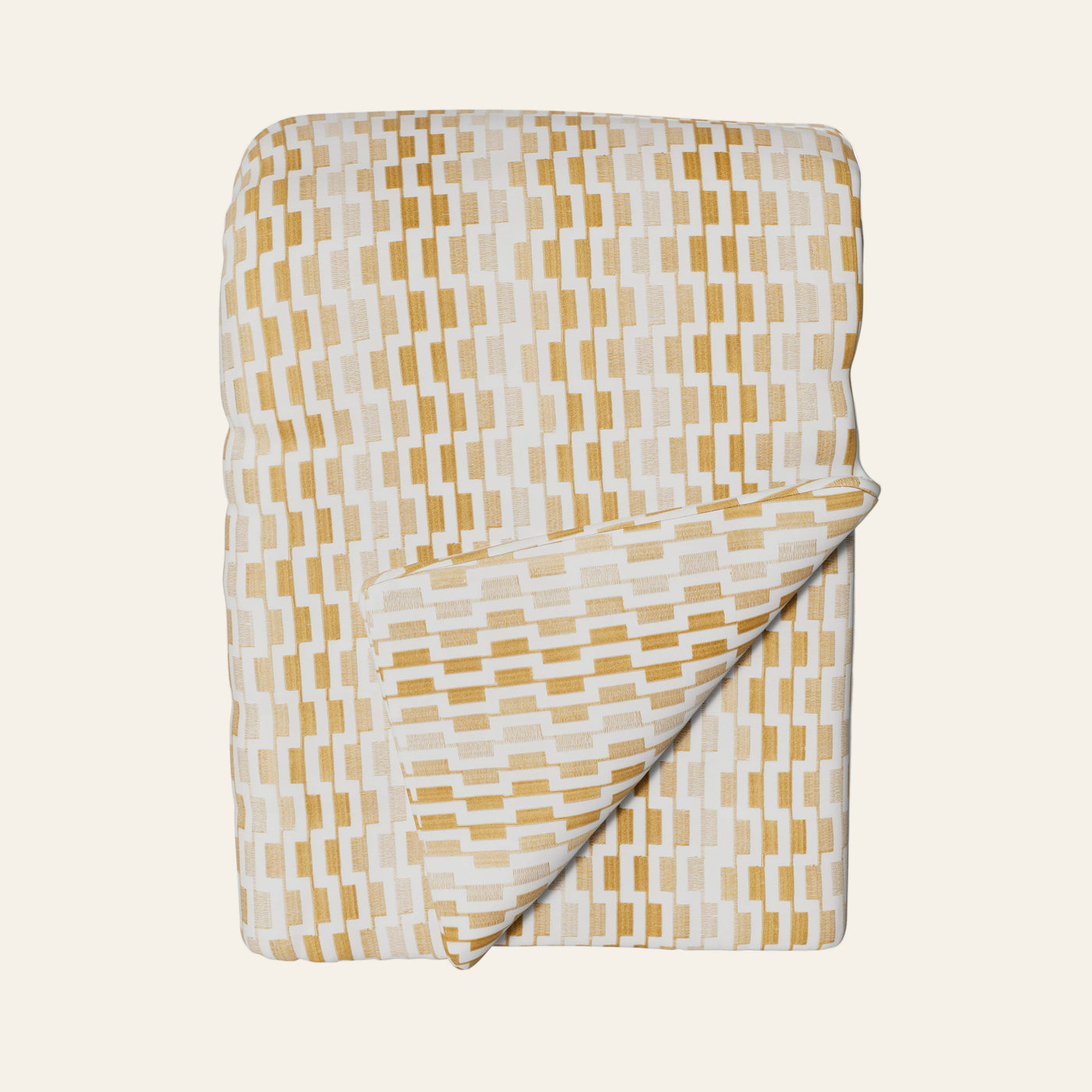 Ann Gish Ingot throw in ivory and gold geometric brick pattern, folded with corner turned back.