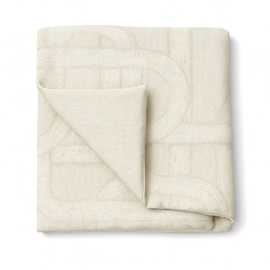 Close-up of folded Ann Gish Interchange throw in ivory with geometric arc pattern.