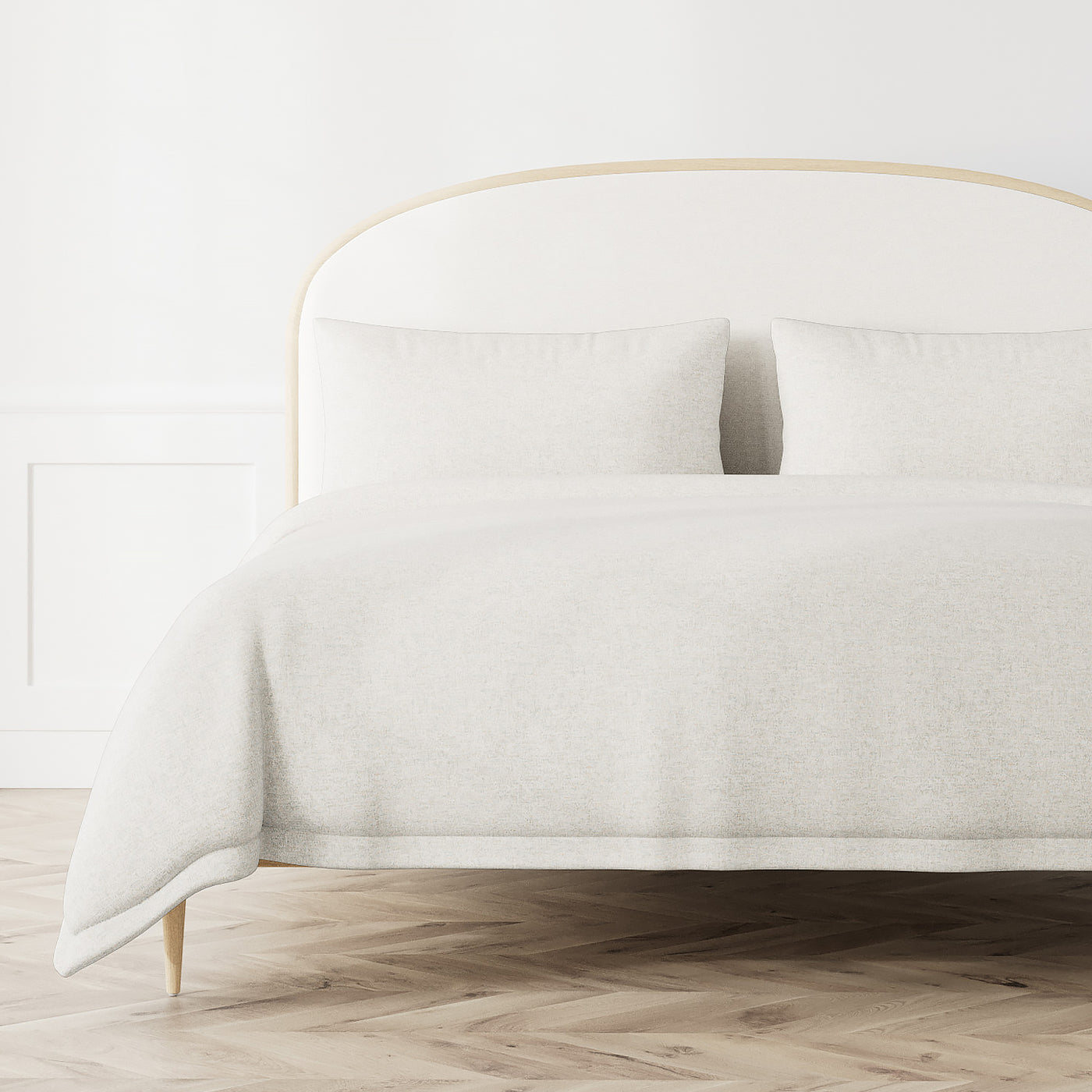 Ivory textured duvet cover draped over a styled bed with matching pillowcases.