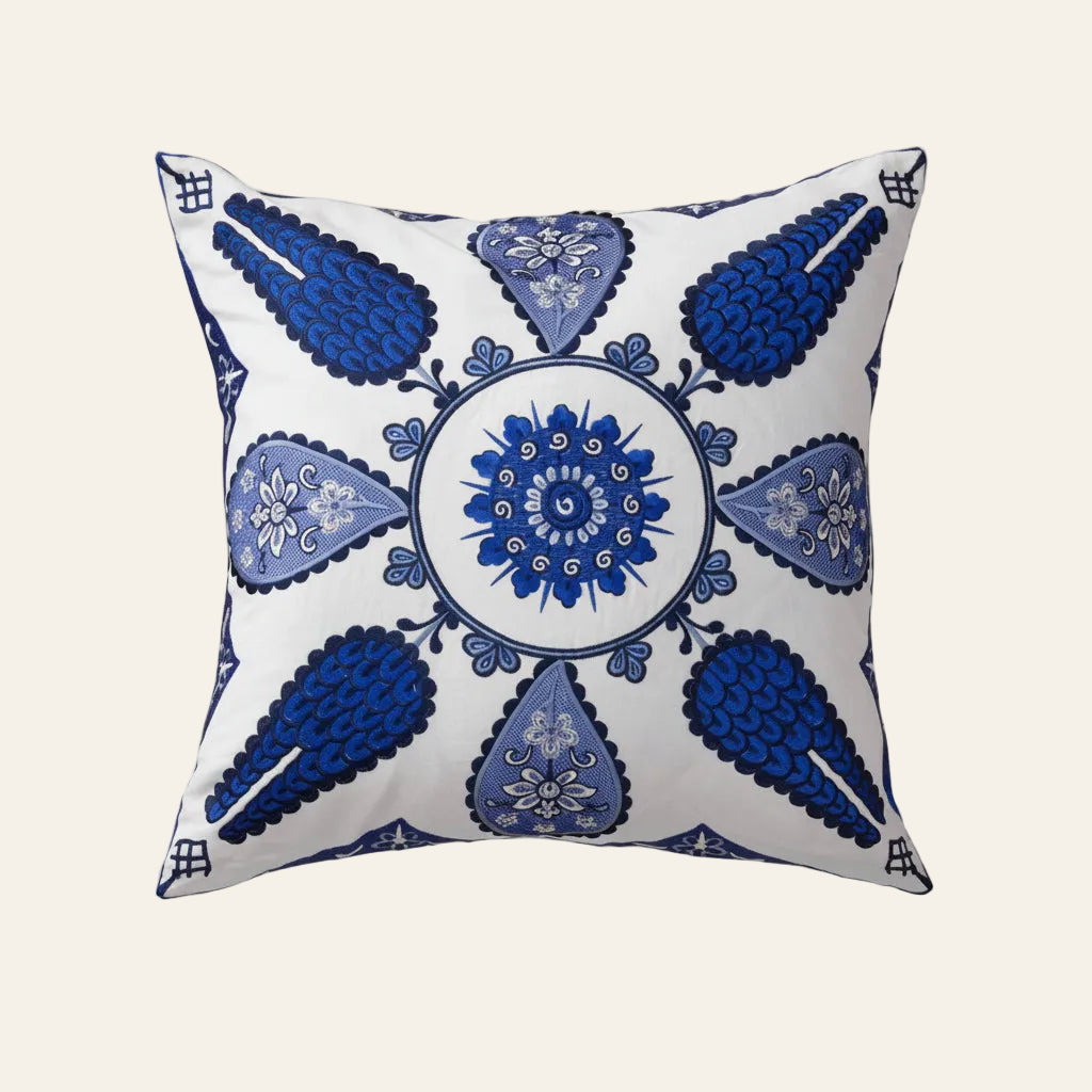 Ann Gish Iznik pillow in white with cobalt blue embroidered medallion and teardrop motifs.