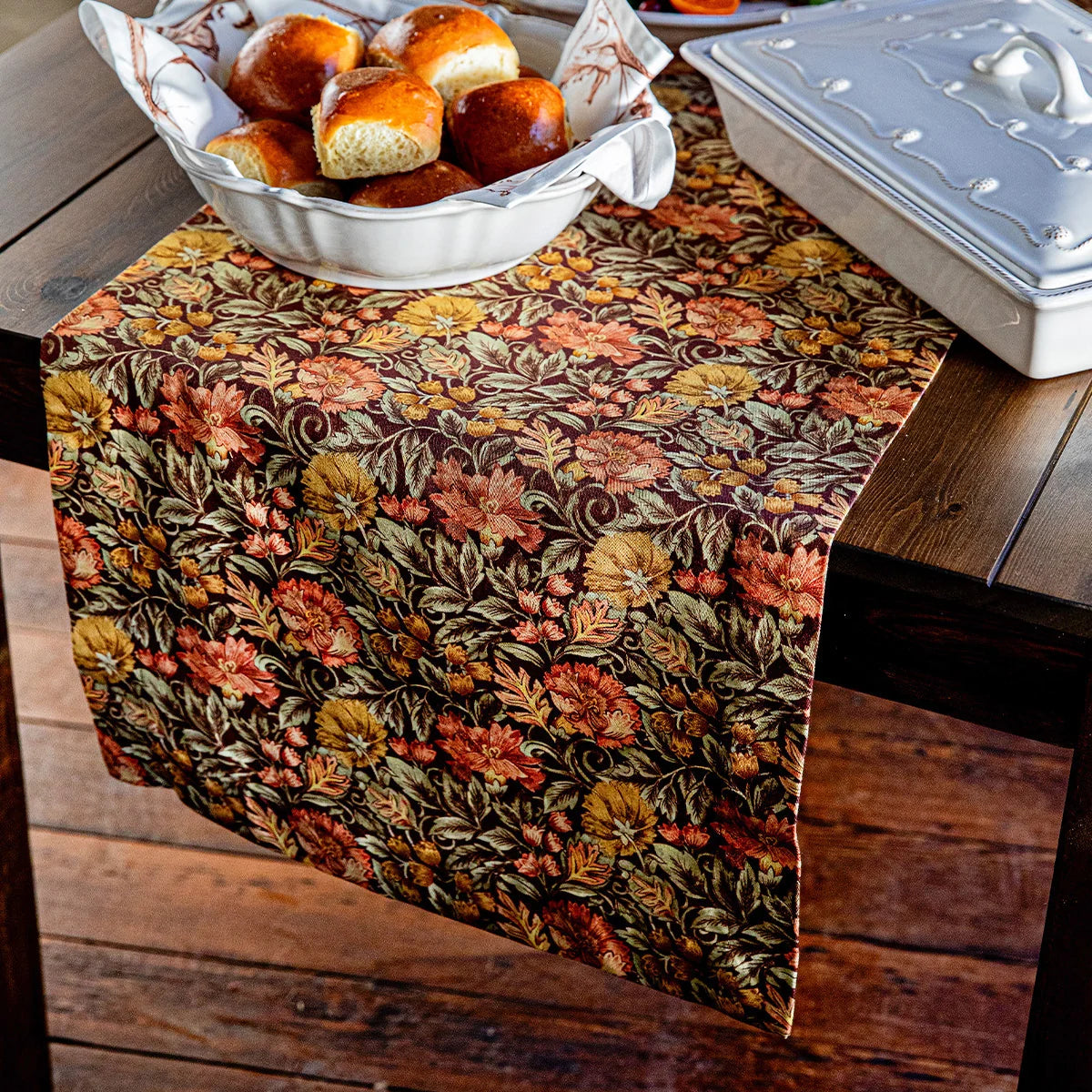 Juliska Willa table runner under a basket of dinner rolls and a white casserole