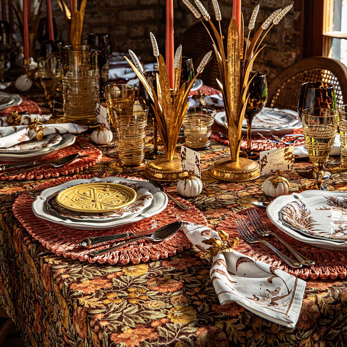 Juliska Willa tablecloth under a fall place setting with gold wheat candelabra and rattan chargers