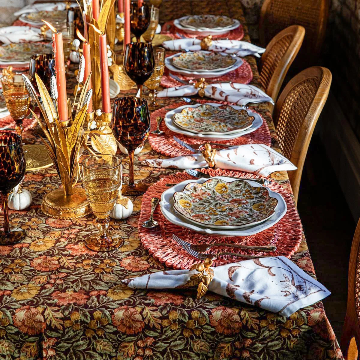 Long table dressed in the Juliska Willa tablecloth with Willa plates, gold candelabra and orange tapers
